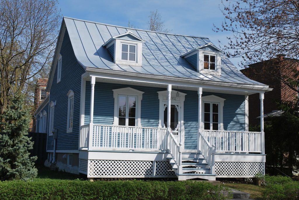 Blue clapboard house with a new standing seam metal roof and dormer windows